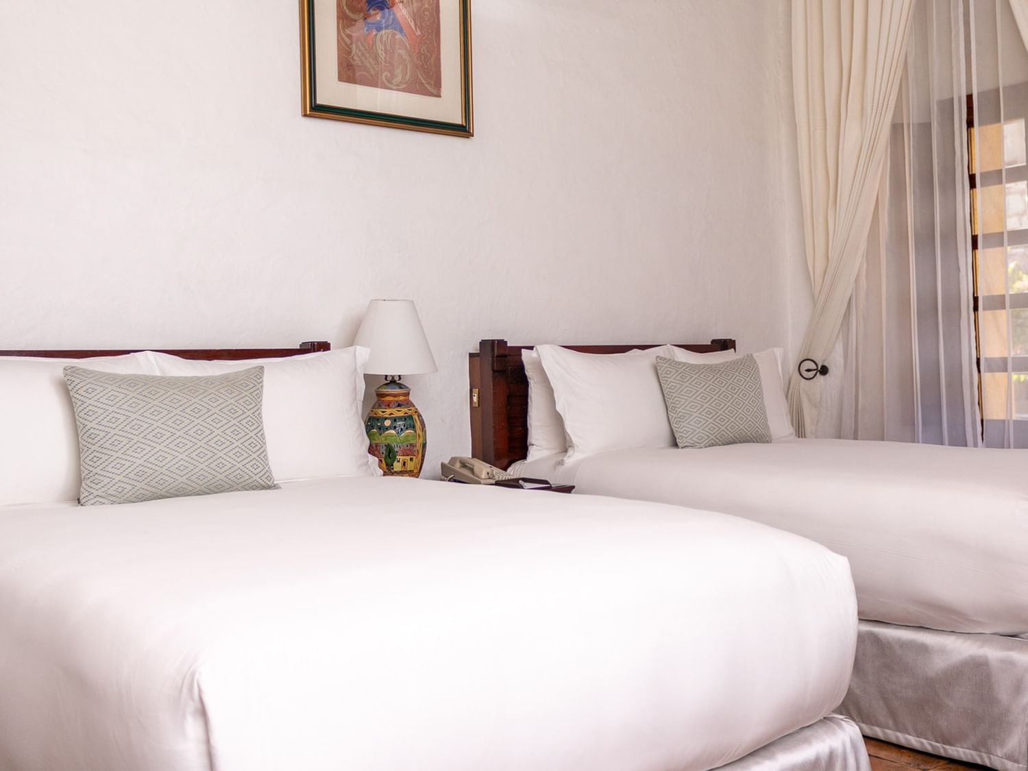 Dos camas dobles con ropa de cama blanca en la habitación Gran Clase en Quinta Real Oaxaca en Oaxaca de Juárez