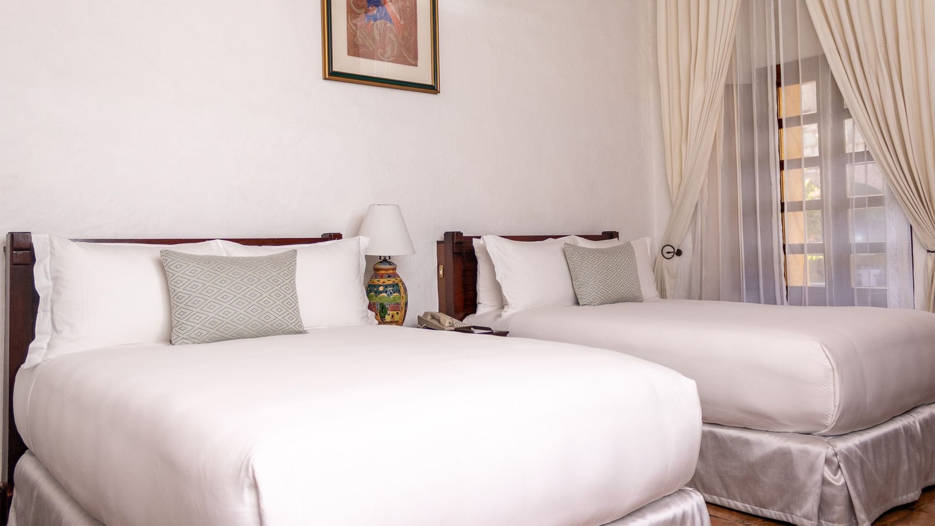 Two double beds with white linens and pillows in a 2 Double Grand Class room at Quinta Real Oaxaca in Oaxaca de Juarez.