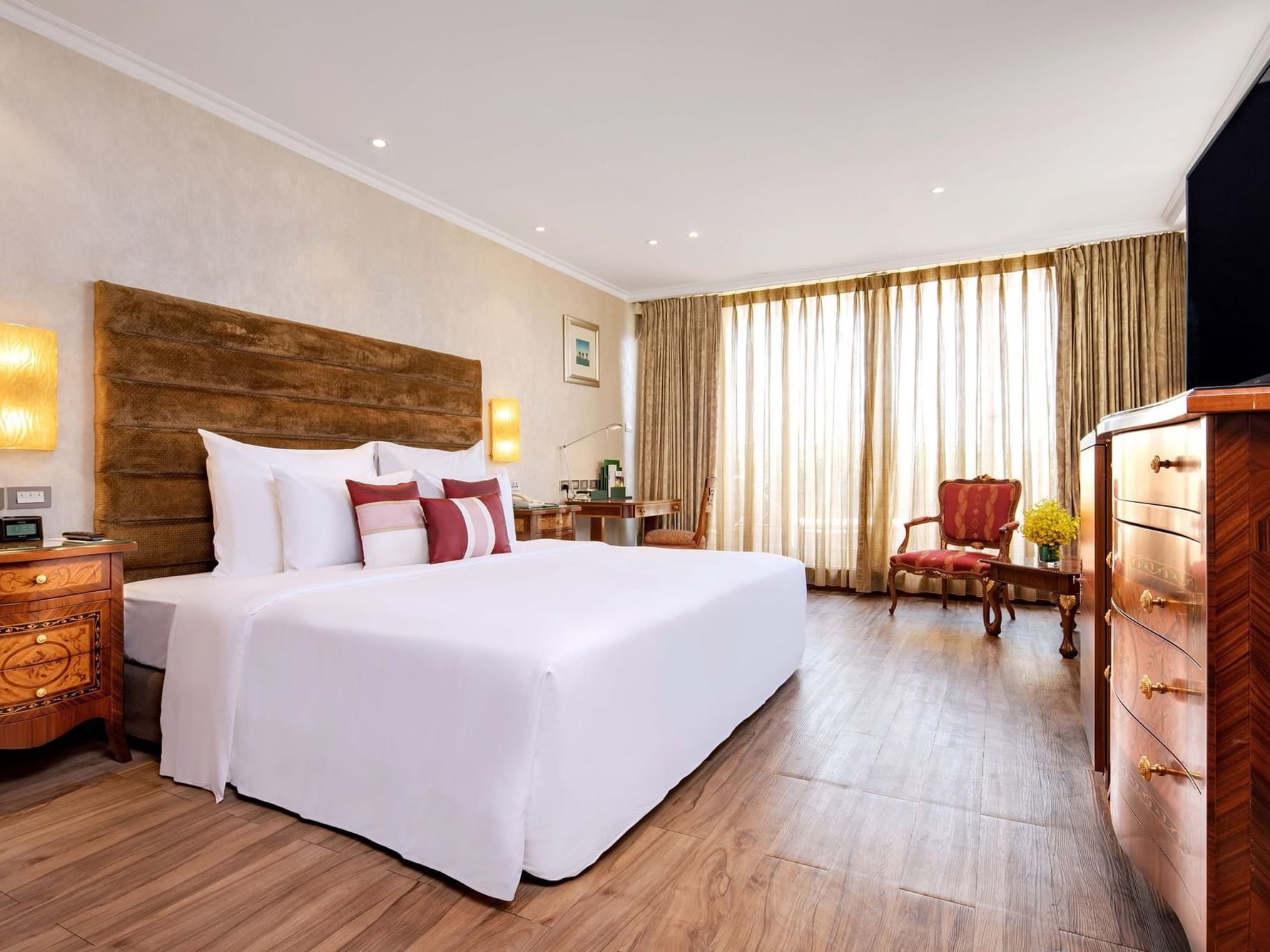 brightly lit spacious hotel room with king bed 