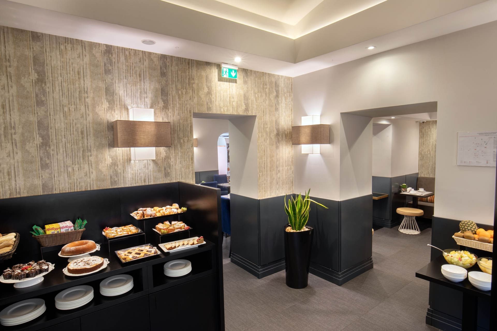 Dining area featuring a buffet with desserts, plates, and potted plants at The Republic Hotel
