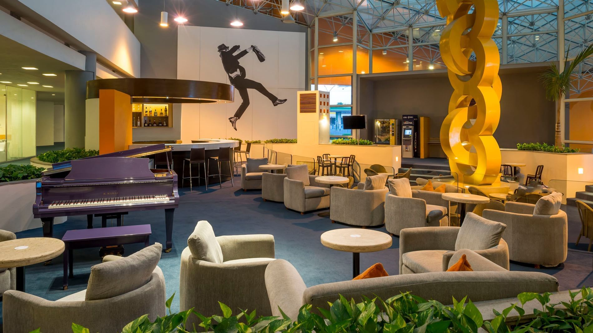 Vibrant Blue Bar featuring a purple piano, a yellow sculpture at Real Inn Nuevo Laredo