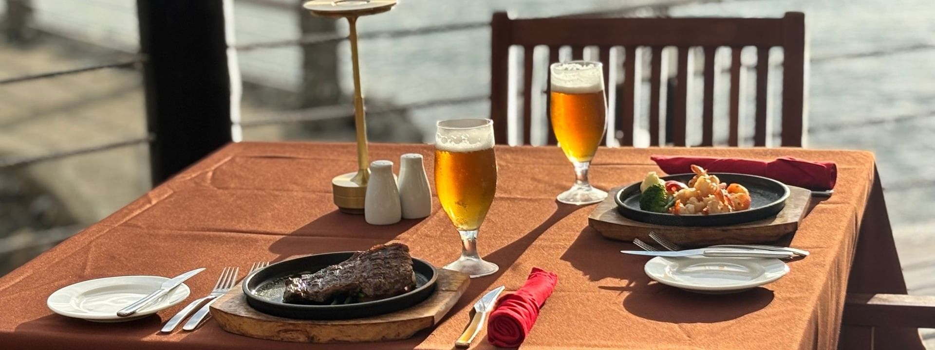 Plated steak and seafood dinner with beer glasses at Warwick Fiji Resort and Spa in Korolevu