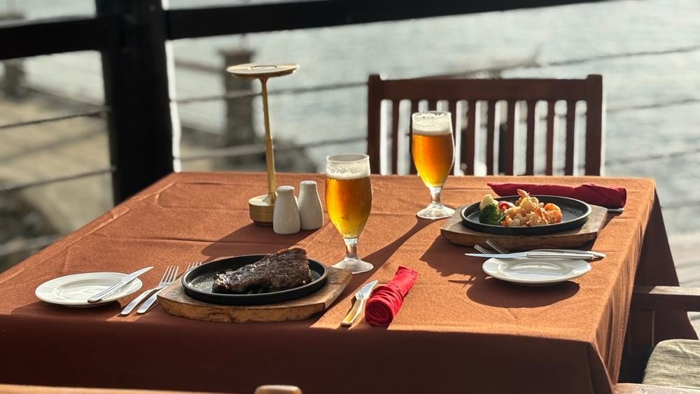 Plated steak and seafood dinner with beer glasses at Warwick Fiji Resort and Spa in Korolevu.