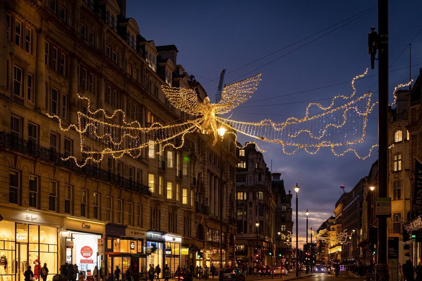 Regent Street adorned with enchanting Christmas lights and a large angel decoration near The Londoner
