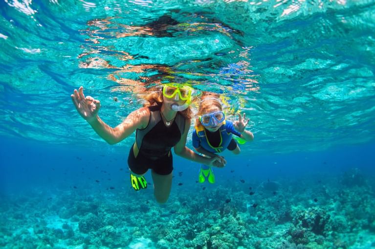 mom and child snorkeling in ocean