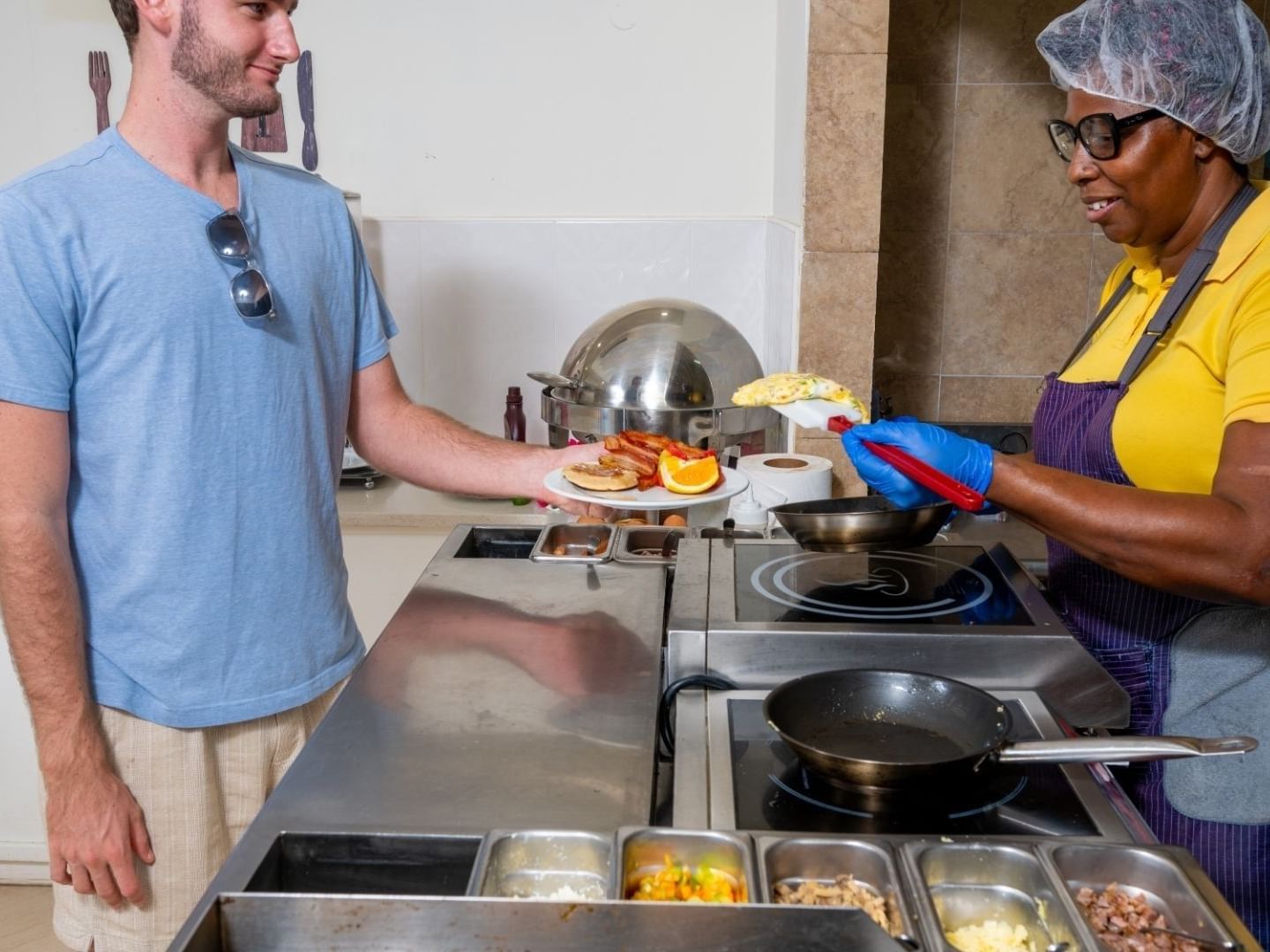 A chef serves a breakfast dish to a customer at Savannah Beach Hotel.