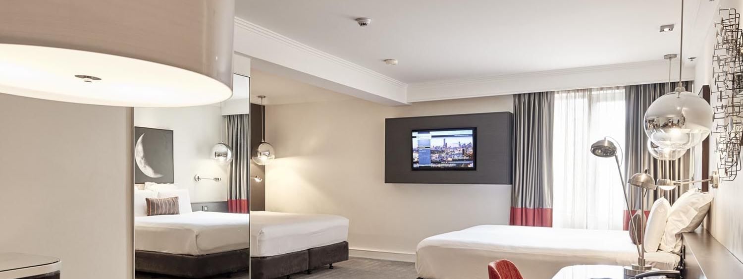 King and queen beds in Deluxe Suite with carpeted floors at Pullman Albert Park