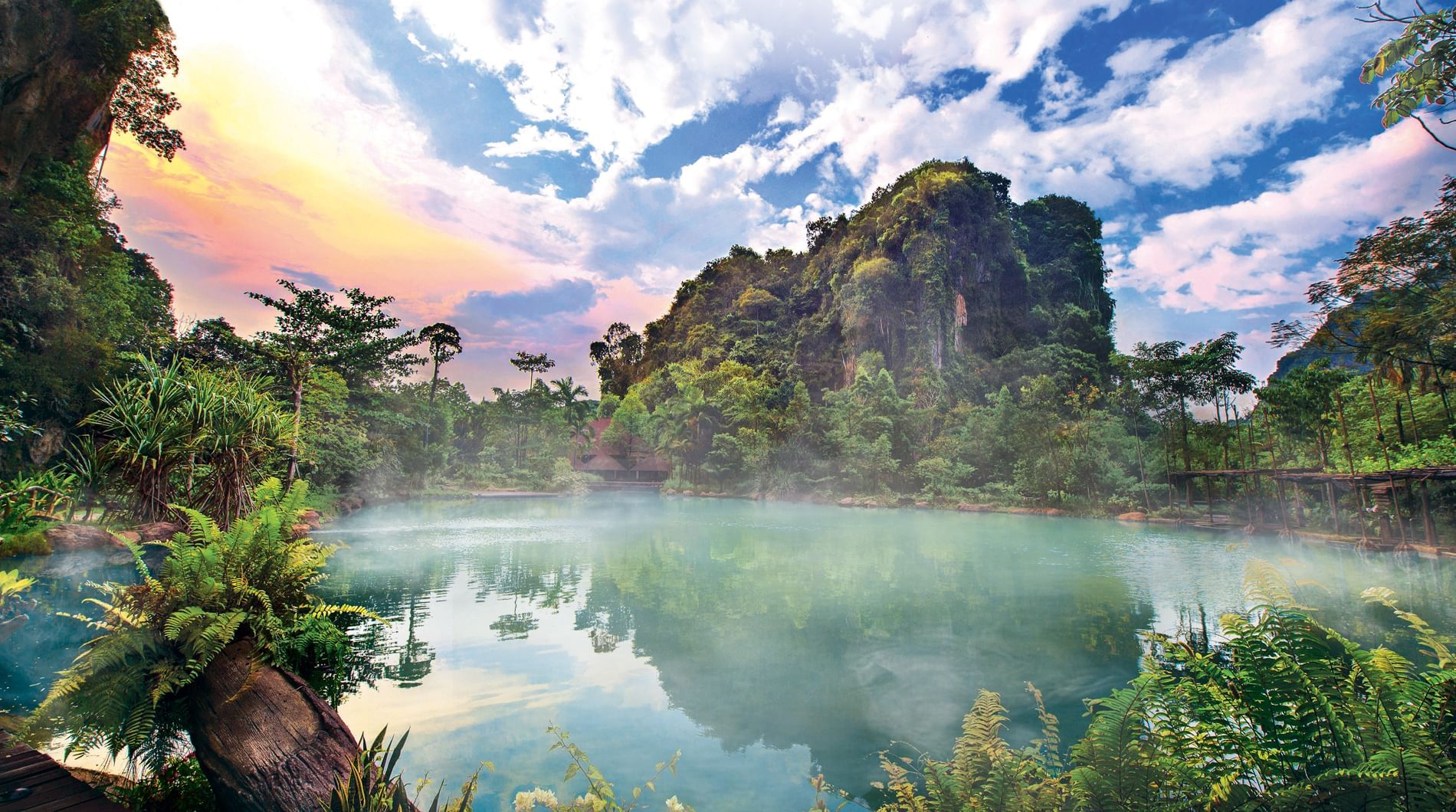 View of a misty lake surrounded by lush cliffs near Sunway Hotels & Resorts