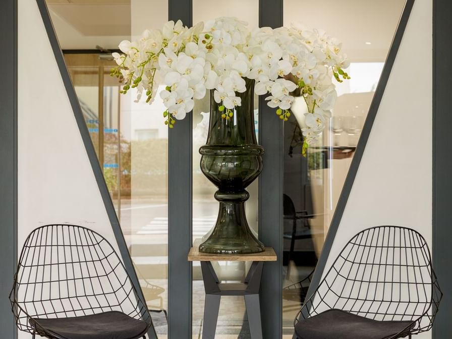  A flower vase between two lounge chairs at Hotel armony