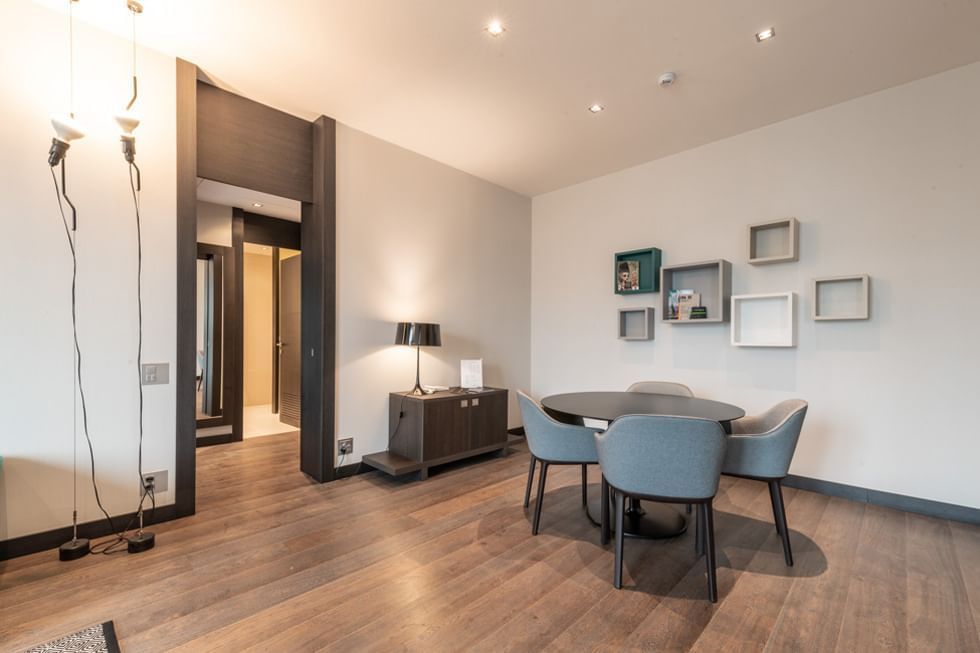 Suite moderna con tavolo e sedie, lampada, mobili e pareti bianche da DUPARC Contemporary Suites