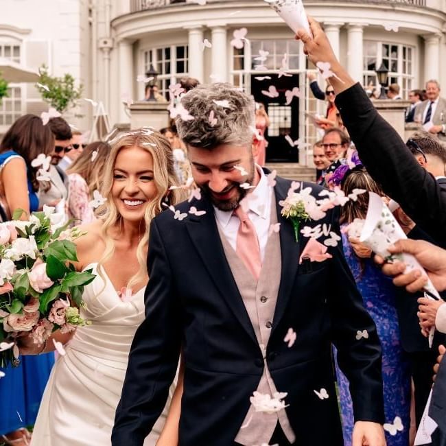 Wedding guests throwing confetti on couple at Gorse Hill featuring our article on 