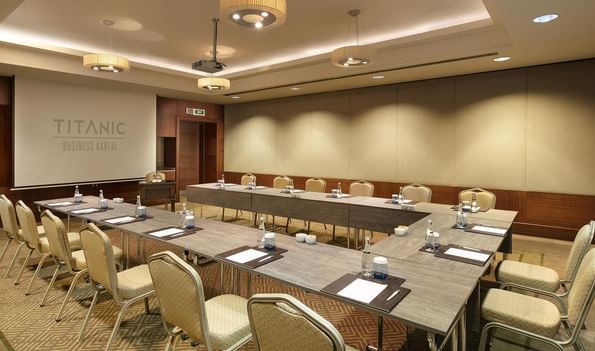 Titanic Business Kartal'daki Borneo 2 salonunda, U düzeninde sandalyelerle hazırlanmış toplantı masası.