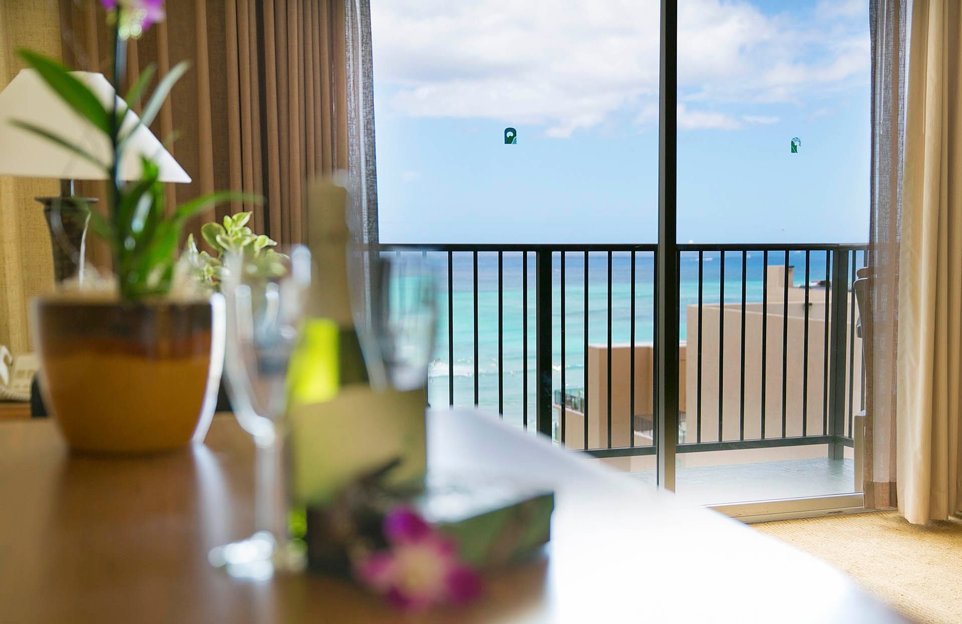 A luxurious room with a balcony overlooking the ocean.