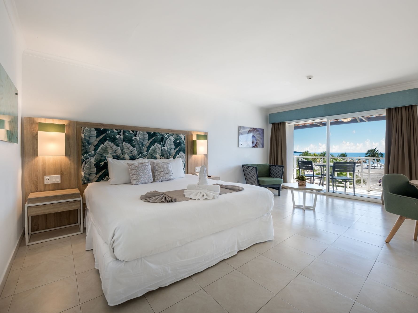 Ocean View VIP room with king bed, tropical headboard, balcony overlooking the ocean at Playa Blanca Resort, Rio Hato