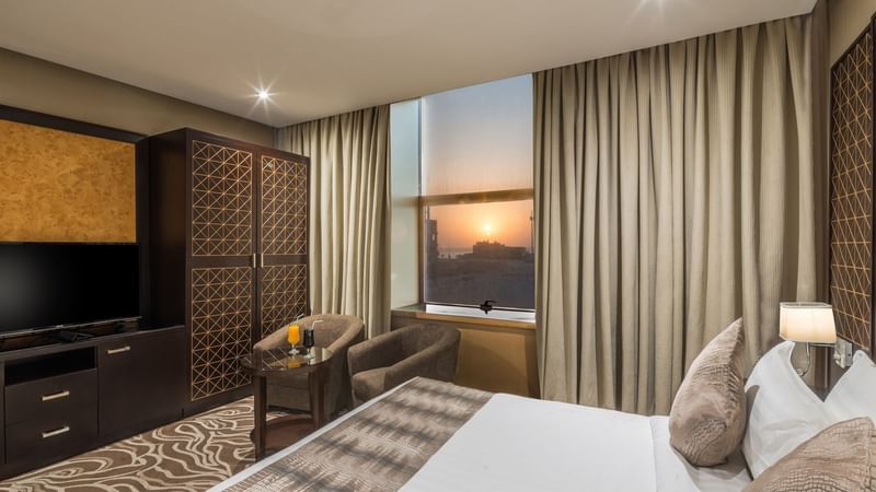 Bed with seating and closet in Deluxe King Sea View at Warwick Hotels & Resorts