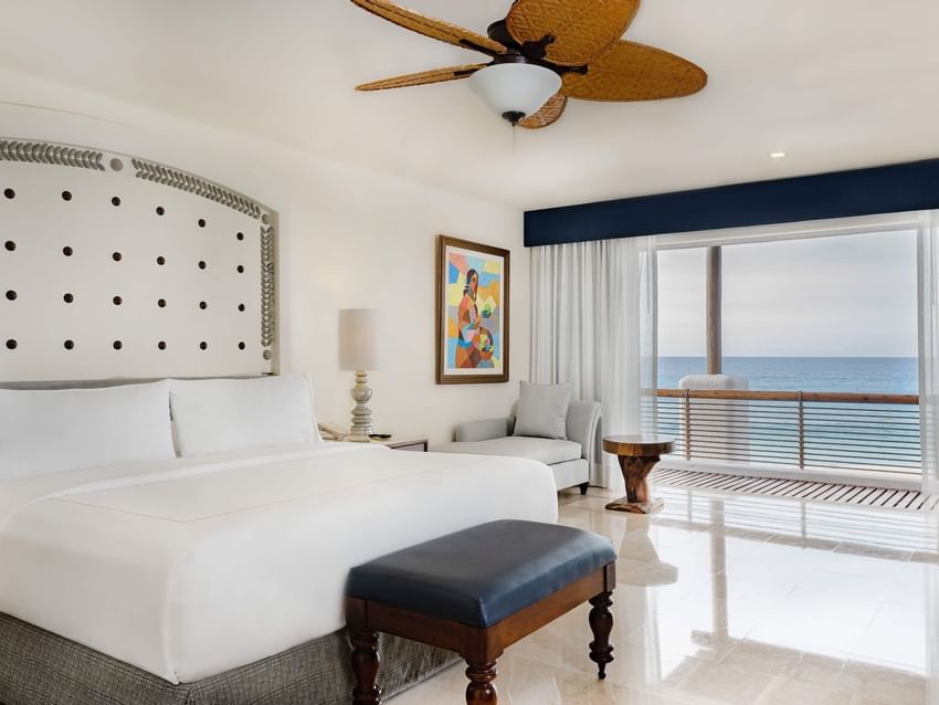 Casita Ocean Front room featuring a comfy bed, couch and a balcony at Marquis Los Cabos Resort