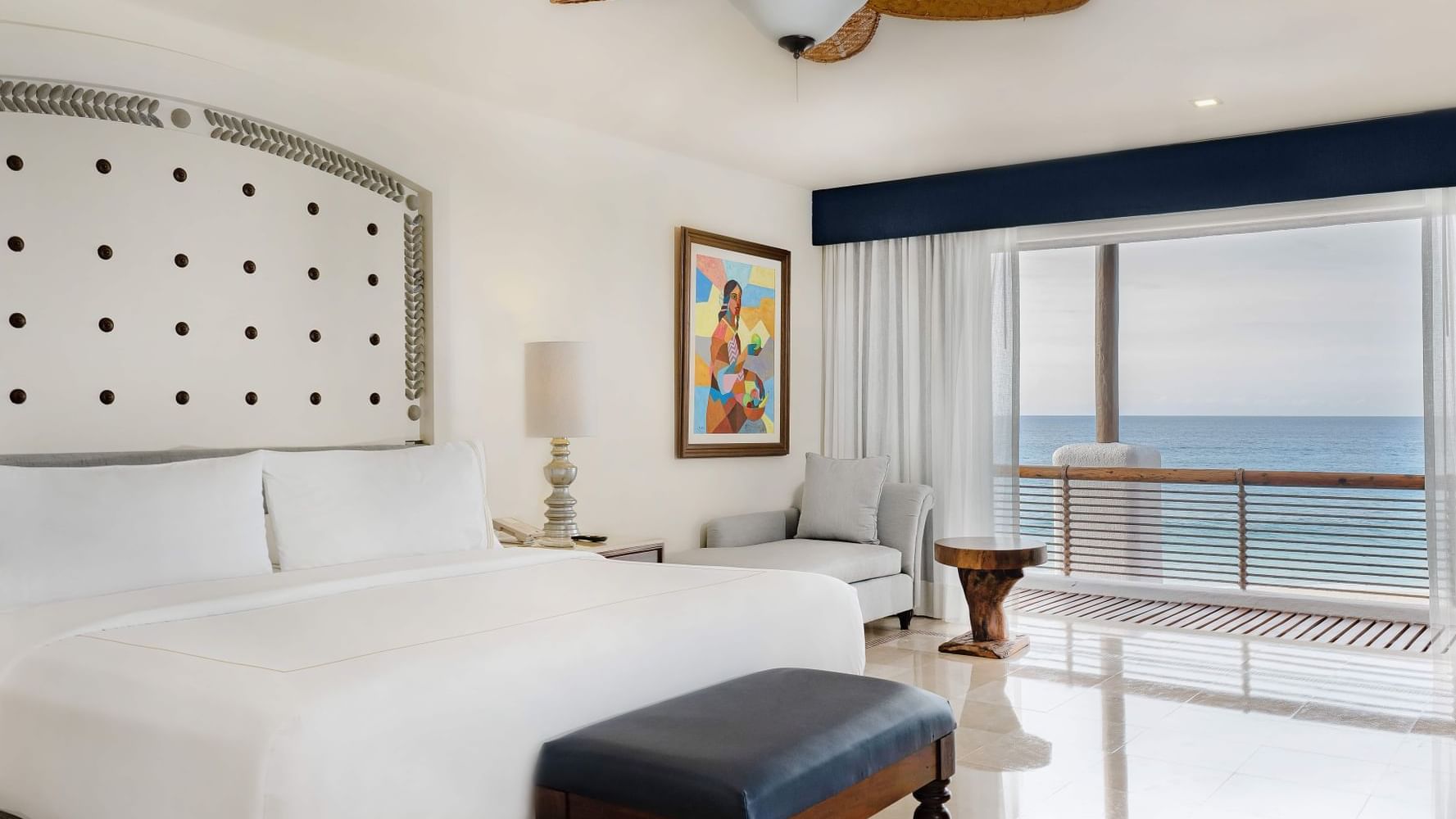 Casita Ocean Front room featuring a comfy bed, couch and a balcony at Marquis Los Cabos Resort