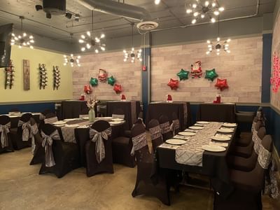 Festive setup with tables and chairs decorated for a Christmas party in Cellar at Fort McMurray Hotels