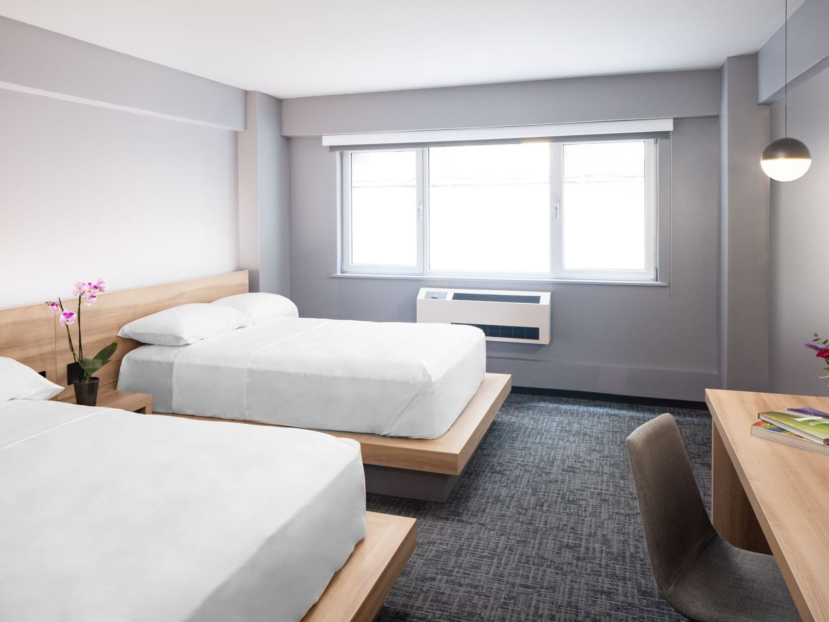 Work desk facing the beds in Deluxe Double Room with carpeted floors at Henn Na Hotel New York