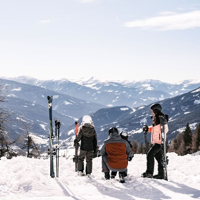 Skiers with equipment looking at snowy mountains near Falkensteiner Hotel Cristallo