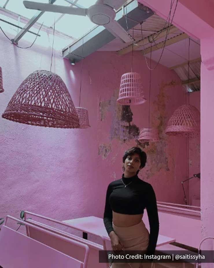 A woman was taking a picture with the pink decorations inside the PIK NIK cafe - Lexis Suites Penang