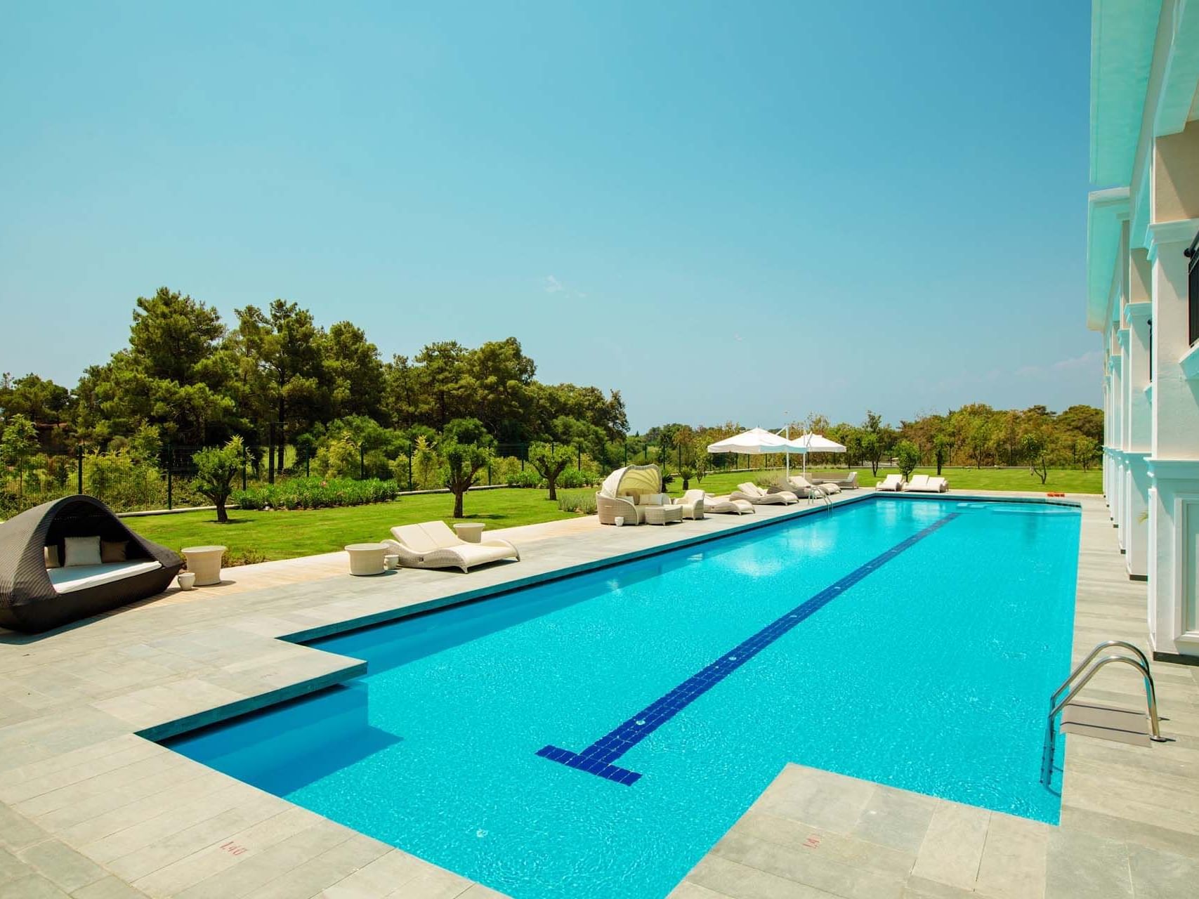 Outdoor pool area with lounges facing Presidential Villa at Titanic Deluxe Golf Belek