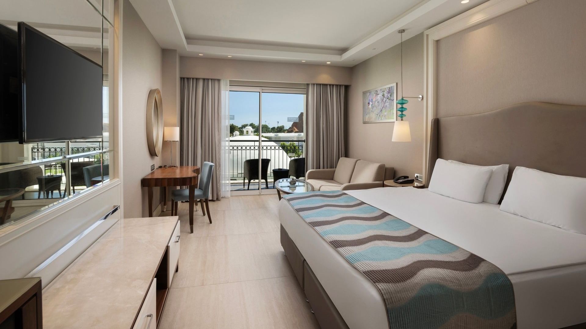 Geniş çift kişilik yatak, oturma alanı ve balkonlu modern Family Suite Main Building , Titanic Deluxe Golf Belek'te.