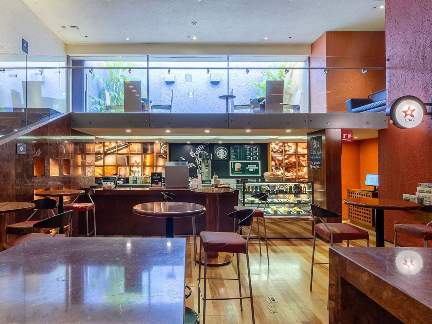 Token Cafe interior with a mezzanine level and warm terracotta walls at Camino Real Polanco Mexico