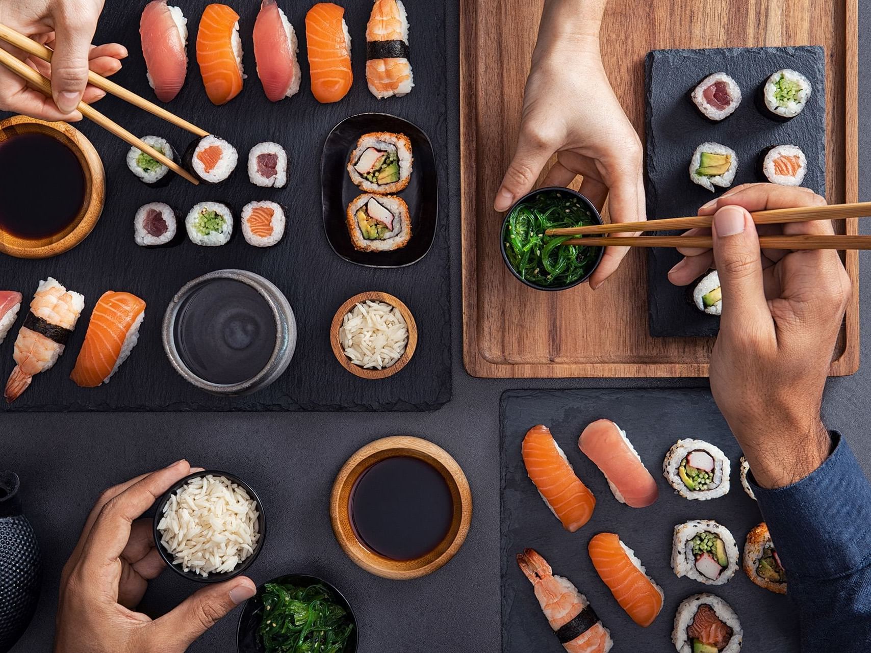 Man and woman sharing sushi with chopsticks at Henn Na Hotel