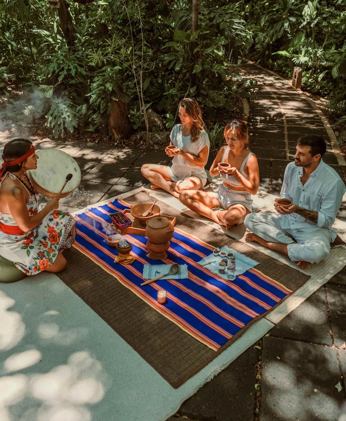 Traditional cacao ceremony in Lahari Wellness Center with guests sitting on mats at Cala Luna Boutique Hotel