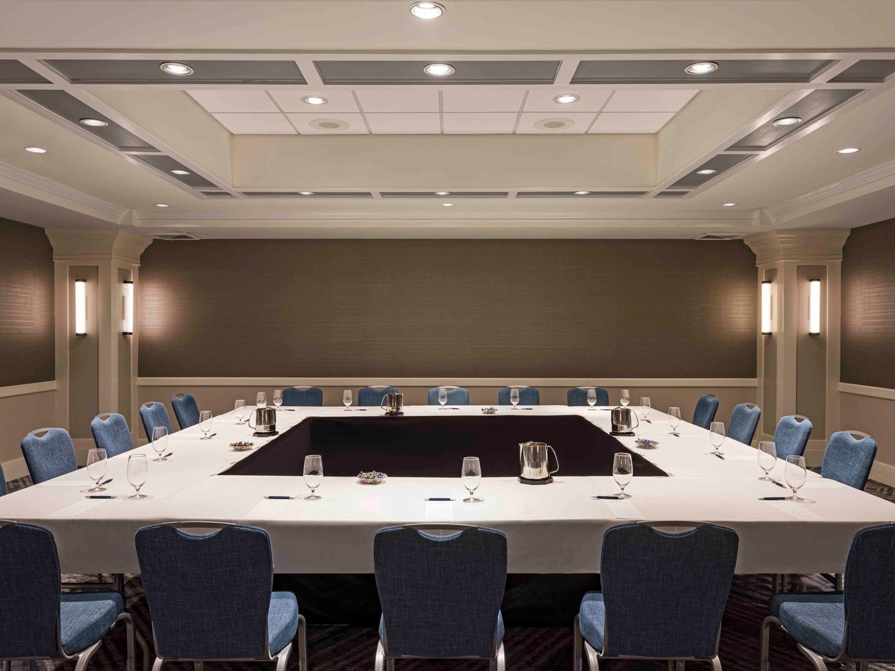 Hollow square conference table setup with blue chairs in Portland & South Portland Rooms at Sable Oaks Weddings and Events