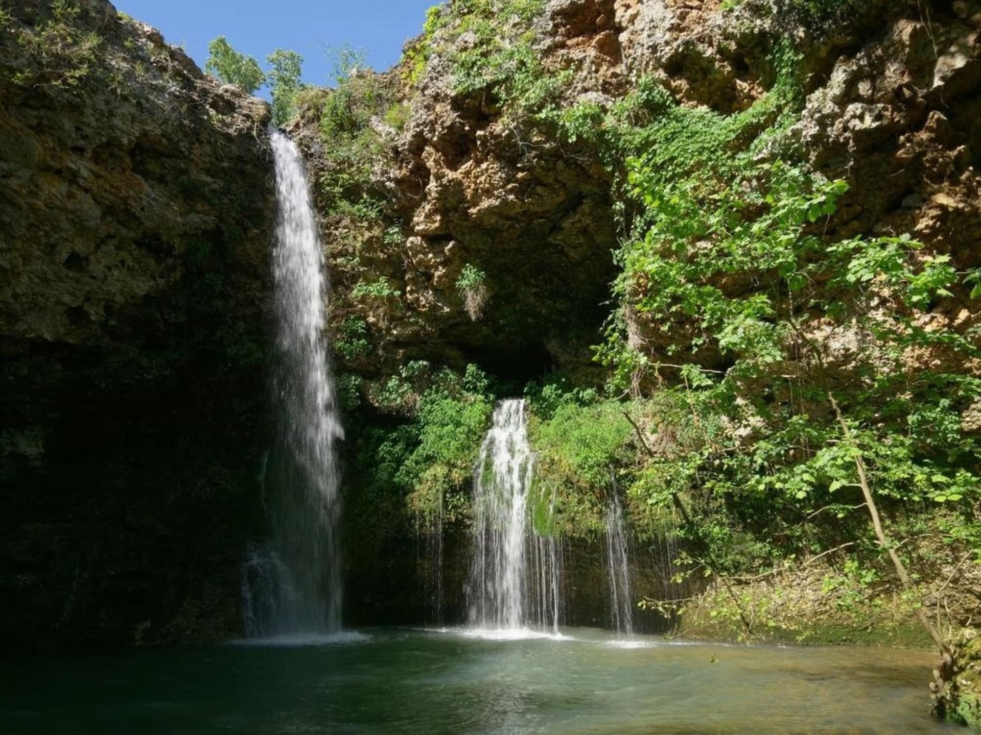 Scenic waterfall cascading into a green pool at Natural Falls State Park near Shangri-La Resort and Golf Club