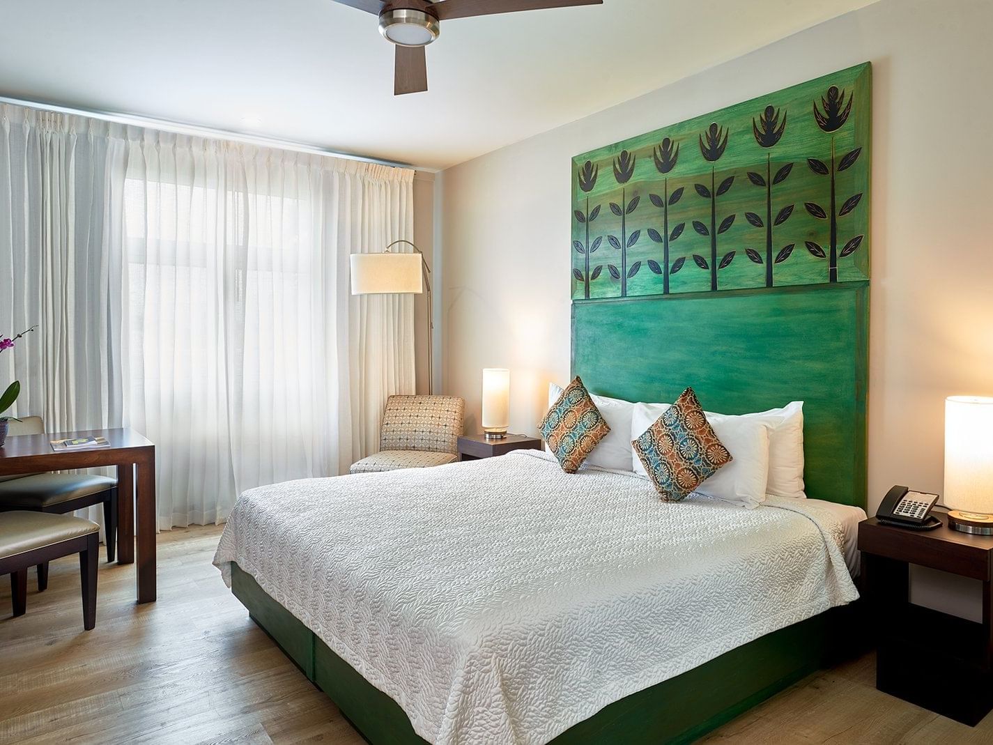 Standard Deluxe with Kitchenette featuring a bed with green headboard, decorative pillows, and modern furnishings at R Hotel Kingston