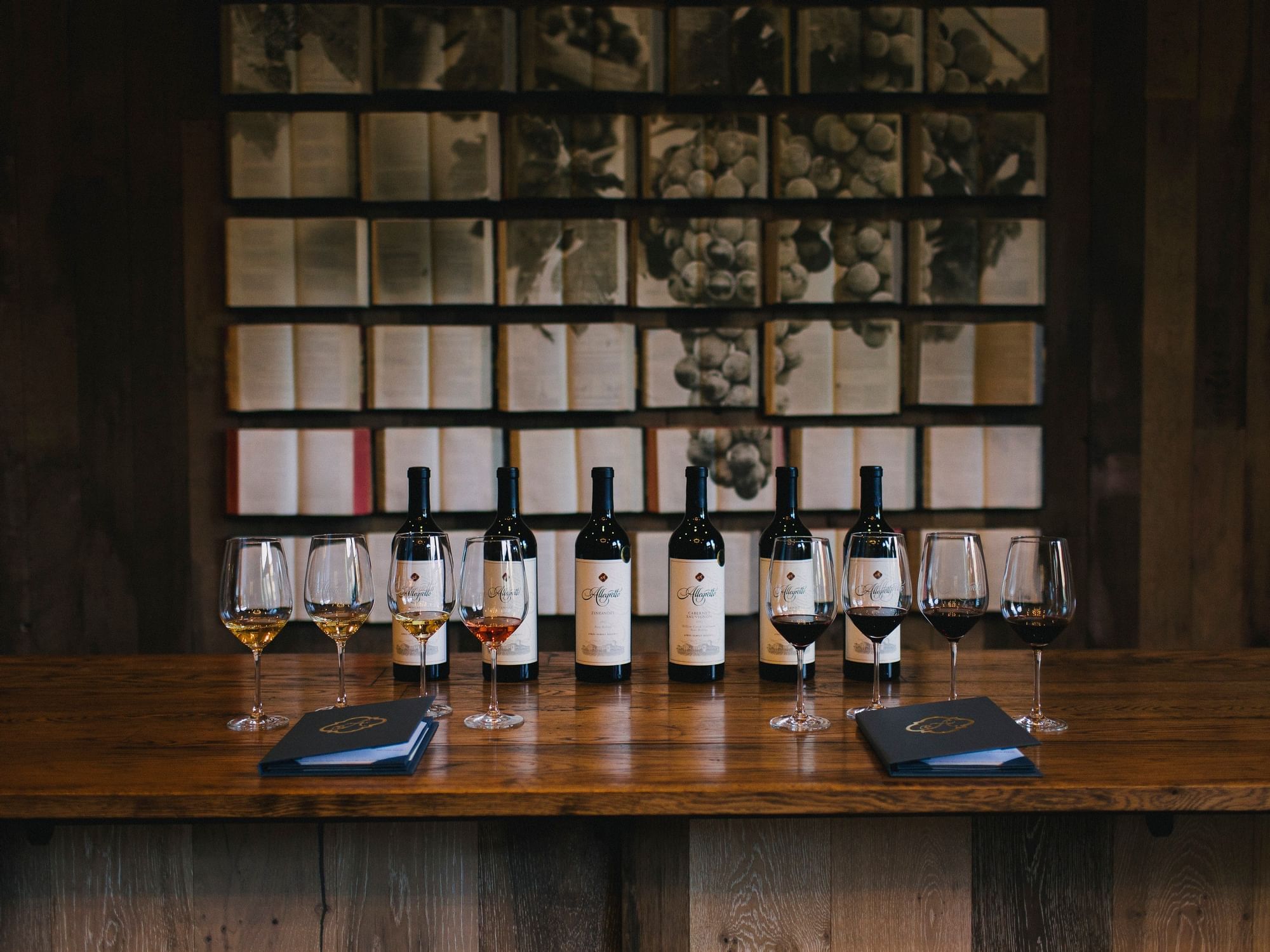 Allegretto's signature wine bottles lined up on a wooden table