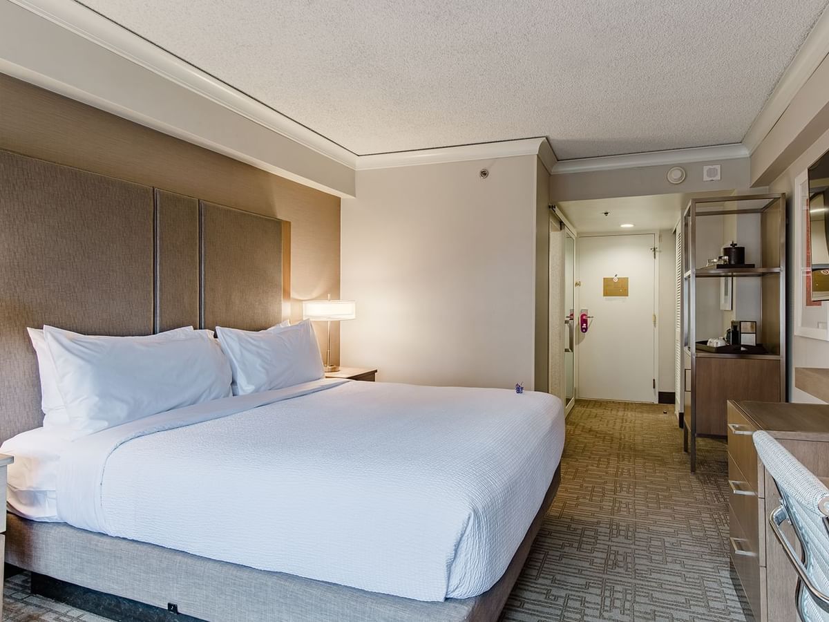 Hotel guestroom with king bed, TV and desk