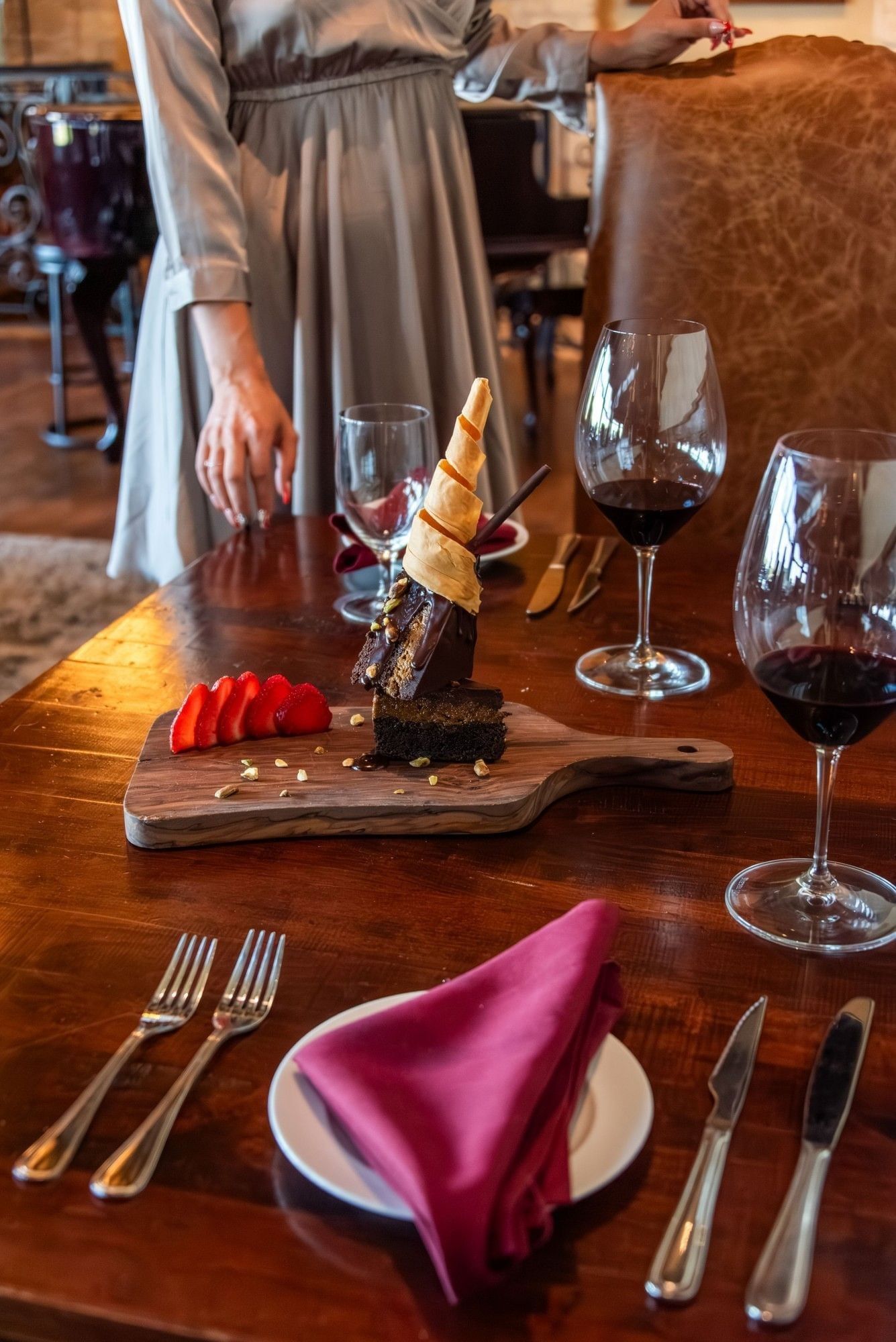 A tall chocolate dessert garnished with a gold spiral on a wooden serving board at Shangri-La Resort and Golf Club