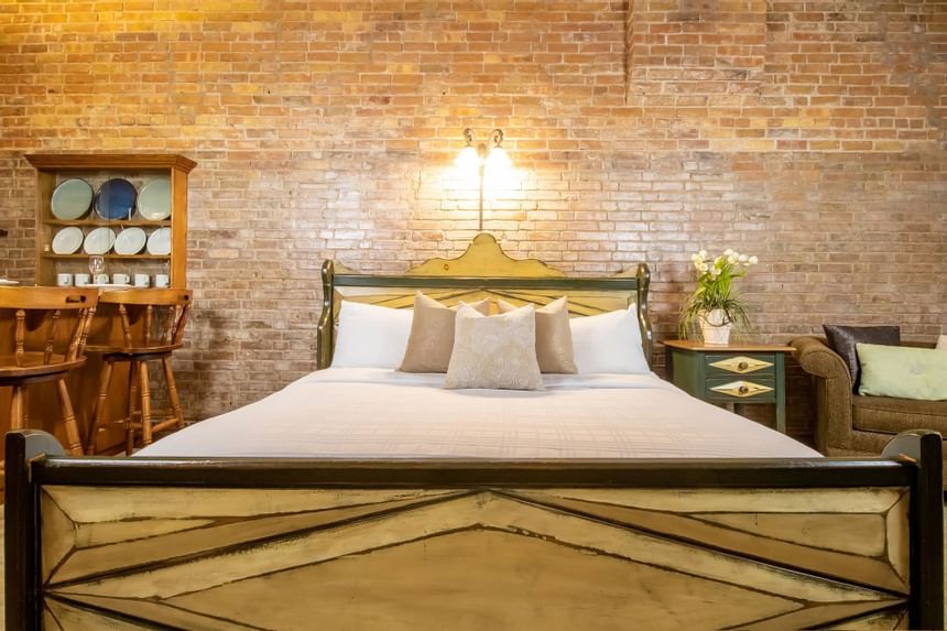 Cozy bed, lamp & bedside cupboard with fresh flowers in King Superior Home Suite Home at Retro Suites Hotel