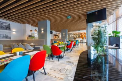 Colorful dining tables and chairs with indoor plant decorations in Metro Jazz Bar & Bistro at Metropol Hotel