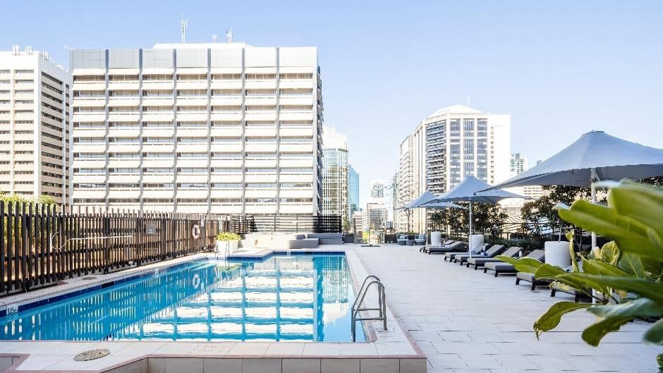 Poolside dining area with a city view at Sofitel Brisbane Central
