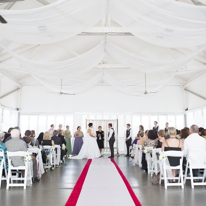 Indoor wedding ceremony with guests sitting under draped fabric ceiling at Mercure Hotel Townsville