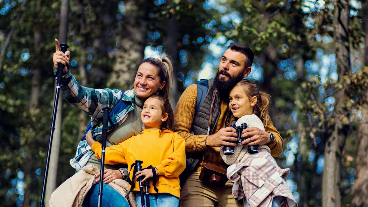 Family of four hiking together in the woods.