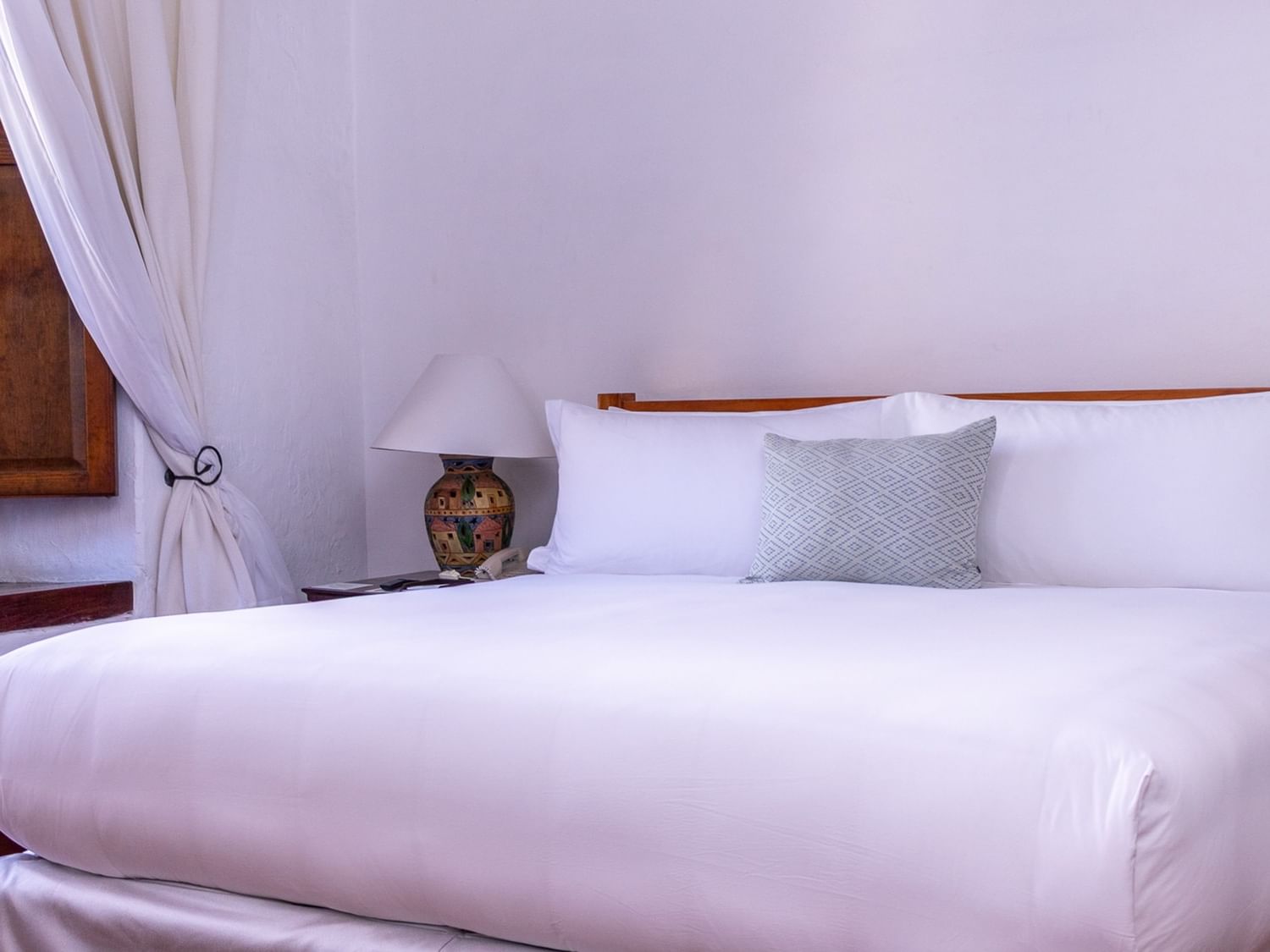 Elegant King Grand Class room with a large bed, white linens, and a cozy pillow at Quinta Real Oaxaca in Oaxaca de Juarez.