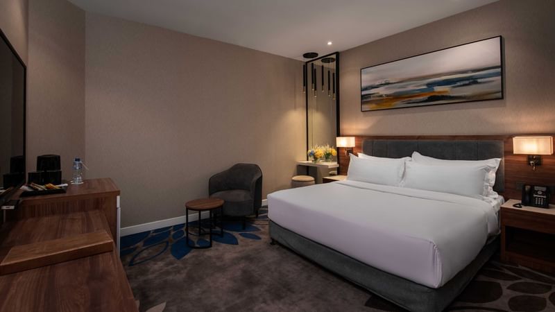 Bed with nightstand and workspace in Standard Room at Warwick Hotels & Resorts