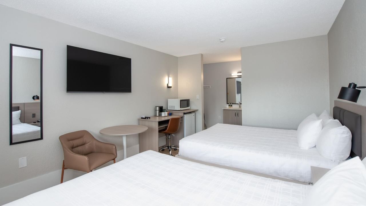 Guest room at Coast Red Deer Hotel with two queen beds, TV and seating area