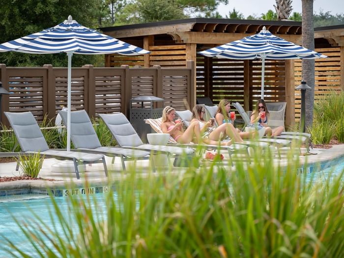 A group of girls enjoy frozen drinks by the pool at Camp Creek Inn