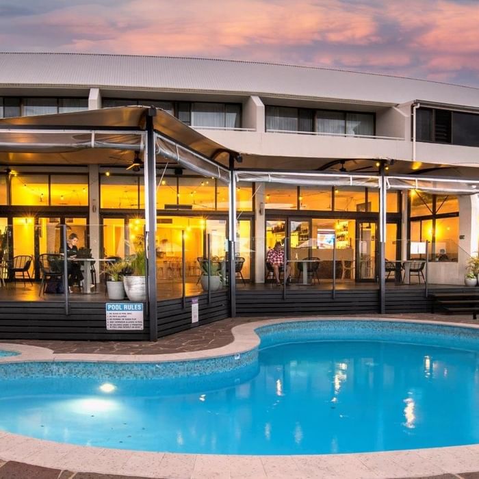 Blue pool with a poolside dining area under a canopy at Mercure Charlestown.