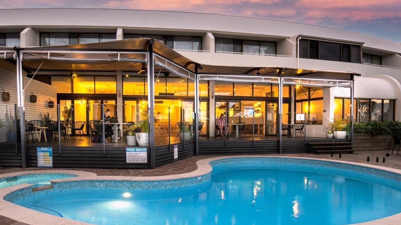Blue pool with a poolside dining area under a canopy at Mercure Charlestown.