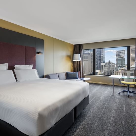 Work desk with a sofa by the bed in Executive Suite at Pullman Sydney Hyde Park