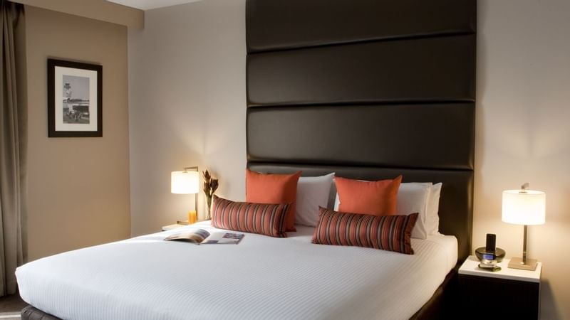 Deluxe Suite with cozy bed and warm lighting at Novotel Sydney International Airport