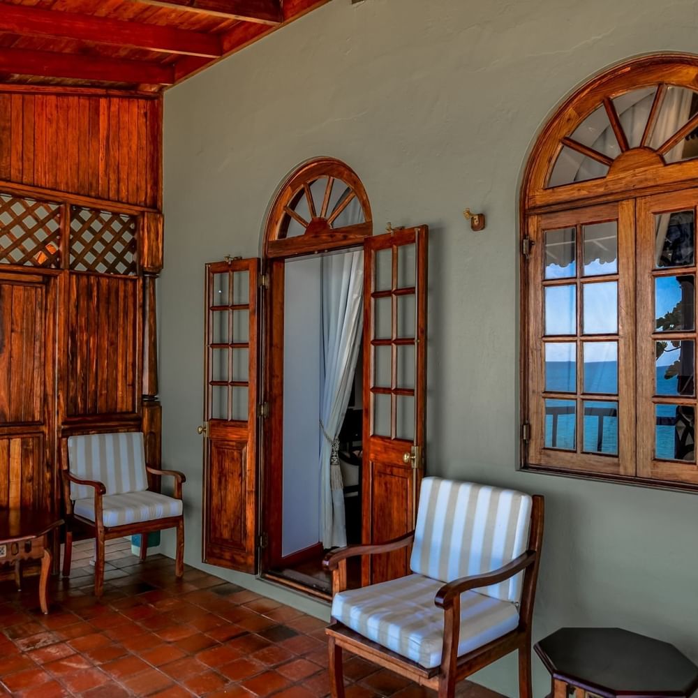 Wooden chairs and tables with ocean view in the Honeymoon Prime Room at Zanzibar Serena Hotel.